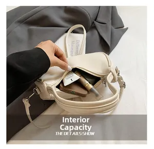 Interior view of off-white dumpling bag showing capacity for phone and cosmetics