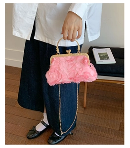 Detail of pink floral petal texture on clutch bag with pearl handle and gold chain