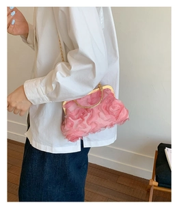 Detailed texture of pink 3D rose petal handbag with gold metal clasp and chain
