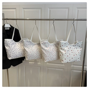 Detail view of four canvas tote bags featuring floral, butterfly, and fruit prints