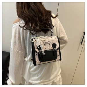 Detail of pink PU leather backpack with bow embroidery and lace pearl accessory