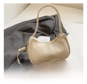 Detail shot of the cream PU leather half-moon bag featuring silver hardware and print