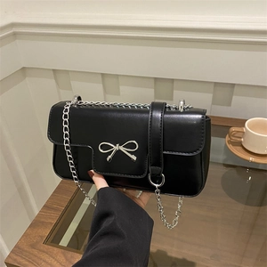 French style black leather underarm bag with silver bow accent and metal chain strap