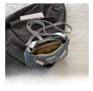 Detailansicht der Denim-Schultertasche mit geräumigem Innenfach für Alltagsgegenstände