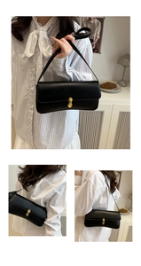Macro shot of smooth black leather texture and gold oval clasp detail on shoulder bag