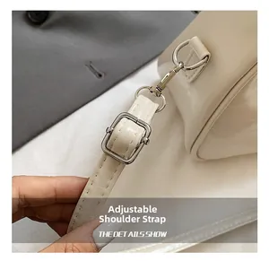 Detail of adjustable cream faux leather strap with silver metal buckle on shoulder bag