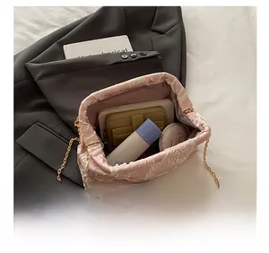 Detailed interior view of pink floral jacquard bucket bag with gold chain strap