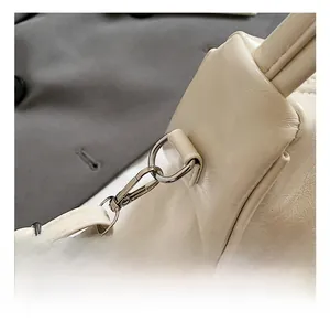 Macro detail of high-quality silver metal hook on the white leather dumpling shoulder bag