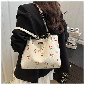 Detailed corduroy tote bag featuring cherry patterns and gold chain with deer charm