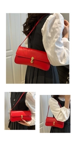 Detail of red baguette underarm bag with gold buckle on model in classic black outfit