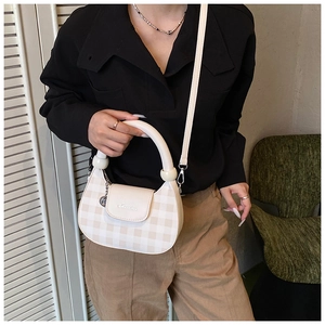 Detail of beige checkered half-moon bag with circular pearl handle and silver logo