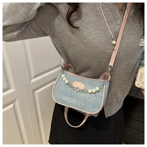 Detail der Mini-Umhängetasche aus Denim mit rosa Lederbesatz und Perlenkette
