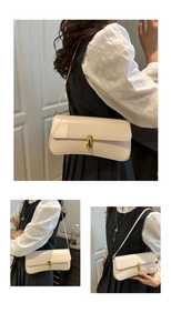 Detail view of cream faux leather shoulder bag with vintage gold clasp on model