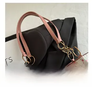 Detail of pink leather handle with gold metal links on a floral tote bag with bear motifs