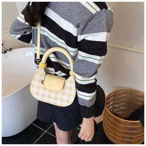Close-up of yellow gingham plaid crossbody bag with leather flap and mini metal logo