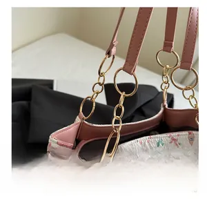 Detail of pink leather strap and gold chain link on cartoon printed tote bag