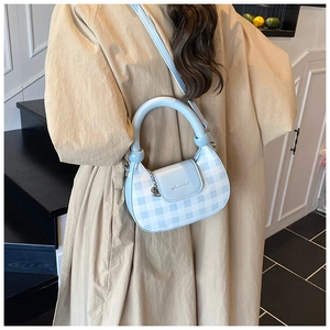 Detail view of the light blue checkered crescent bag with adjustable shoulder strap