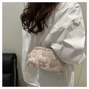 Detail of pink embroidered floral bag with delicate gold chain strap and cloud ruffles