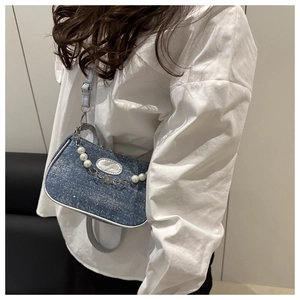 Details der dunkelblauen Denim Umhängetasche mit Perlenkette und Fashion-Metallplakette