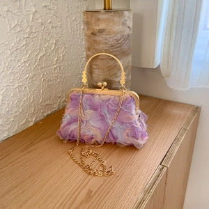 Detail of 3D rose petal shell bag with gold metal handle and crossbody chain strap