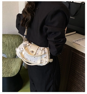 Détail d'un sac bandoulière crème chic avec motifs de lapins noirs et garnitures argentées