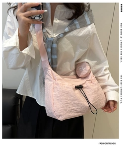 Pink pleated nylon tote bag with a small coin purse and decorative drawstring detail