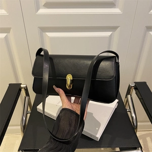 Minimalist black leather underarm bag with gold metal buckle and sleek rectangular design