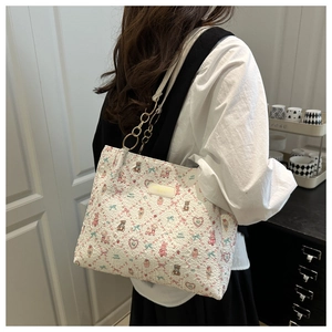 Détail du sac cabas matelassé blanc avec motifs d'ours colorés et garniture dorée élégante