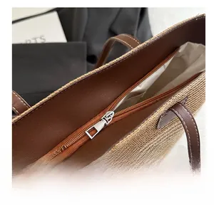 Détail du sac en paille tressée avec fermeture éclair en métal et finitions en cuir
