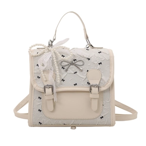 Mini sac à dos crème avec imprimé nœuds noirs et breloque en perles pour femme