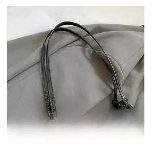 Detail shot of black glossy textured leather handles with metal adjustable buckles