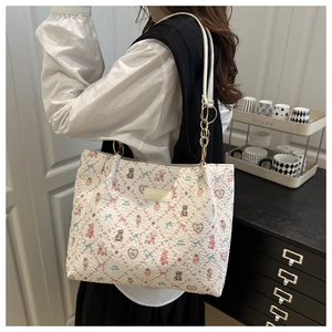 Détail du sac cabas floral avec motifs d'ours en relief et bandoulière chaîne dorée