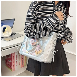 Détail du sac ita argenté avec fenêtre en PVC transparent et rubans lacés sur le côté