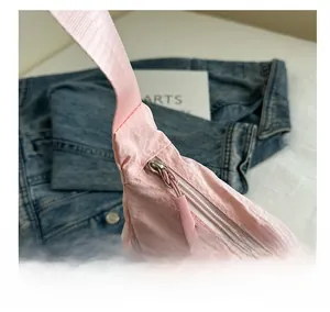 Close-up of a smooth pink nylon bag zipper and premium light fabric texture details