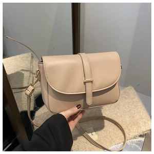 Dettaglio borsa in pelle beige con fibbia dorata e patta elegante vista da vicino