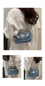 Detail der Jeans-Tasche mit Perlen- und Blumenkette sowie Fashion-Lederetikett