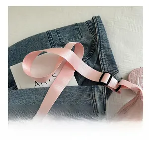 Detail of pink nylon half-moon crossbody bag with wide adjustable strap and zipper