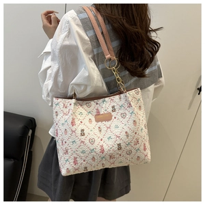 Detail of floral tote bag with pink straps and cute cartoon rabbit patterns