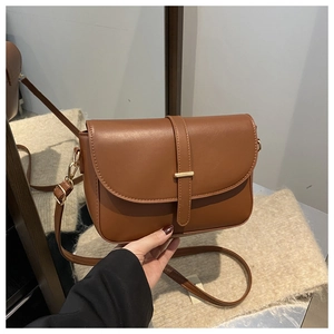 Dettaglio della borsa in pelle color caramello con fibbia dorata e finitura di alta qualità