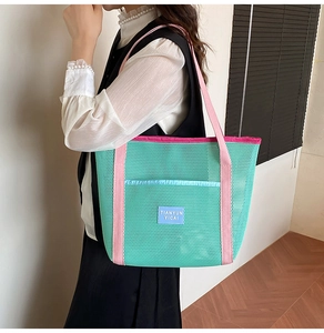 Detail of colorful mesh tote bag showing teal nylon fabric and pink shoulder straps
