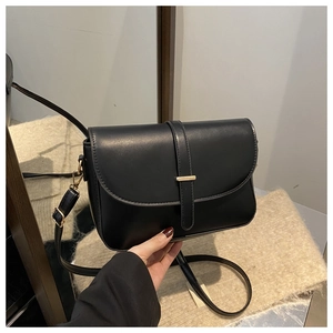 Dettaglio borsa in pelle nera a concia vegetale con finiture dorate e tracolla regolabile