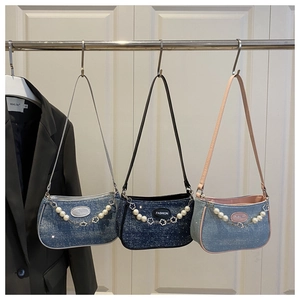 Details von Denim-Umhängetaschen mit Perlenketten und Modeetiketten in drei Blautönen