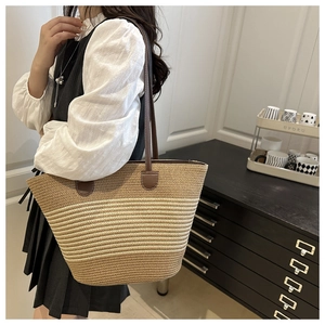 Vue détaillée du sac cabas en paille rayé avec des anses d'épaule en cuir marron chic