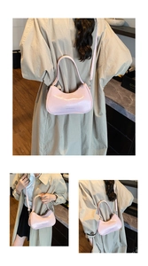 Detail of pink glossy crescent underarm bag showing shoulder and crossbody styling options