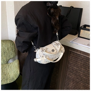Détail de la texture gaufrée blanche d'un sac cylindrique avec bandoulière en chaîne