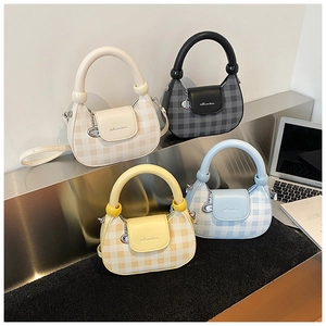 Detail of trendy checkered crossbody bags in four colors on a modern desk setup