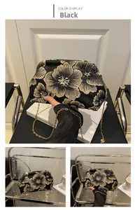 Close-up of black shell bag featuring golden floral embroidery and fine gold chain strap