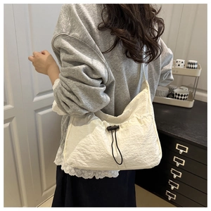 Lifestyle view of white minimalist tote bag with drawstring detailing on casual shoulder strap