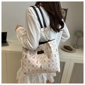 Détail du sac cabas matelassé avec imprimés oursons, chaîne dorée et bandoulière noire