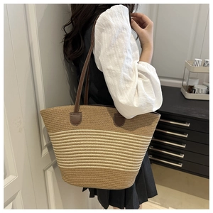 Détails du sac cabas rayé en paille avec bandoulières en cuir marron et texture tissée
